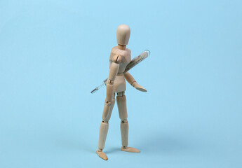 Wooden mannequin with a thermometer on a blue background. Feeling unwell, illness