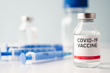 A single bottle vial of Covid-19 vaccine. Medical concept vaccination hypodermic injection...