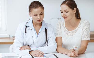 Fototapeta premium Doctor and patient sitting at the desk. Medicine and health care concept