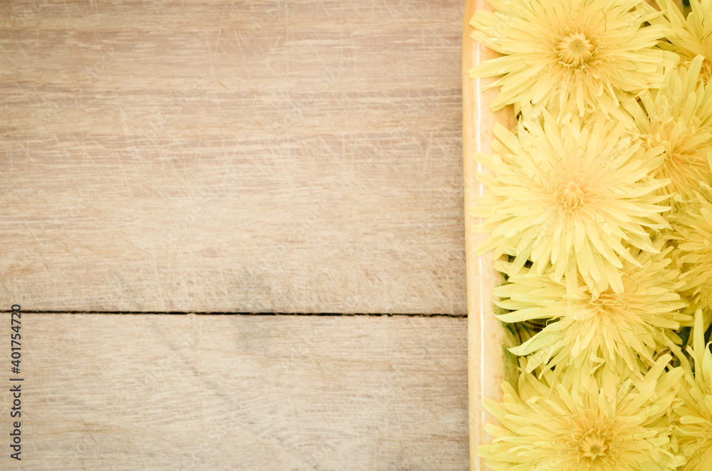 Sticker a top view of blooming yellow dandelion flowers on a wooden table with copy space - perfect for wall