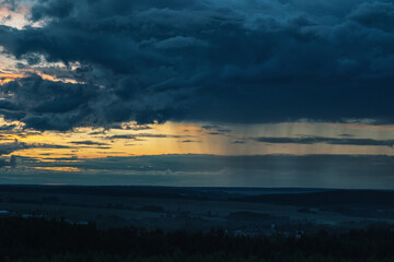 Deep blue rainy clouds and  some rays of light