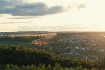 Suburbs on a sunny day, field and forest. Electro wires line