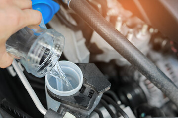 Filling the Windshield Washer Fluid in the Car. Automobile Maintenance Concept.