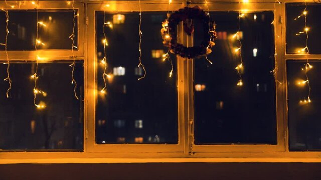 Atmospheric Christmas window decorated with yellow twinkle lights