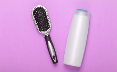 Fototapeta na wymiar Hair brush with shampoo bottle on pink pastel background. Hair care. Hygiene. Beauty flat lay. Top view