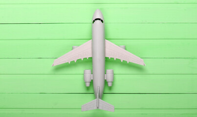 Air Tourism or travel flat lay. Airplane figurine on green wooden background. Top view