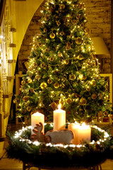 christmas tree with candles and decorations. Christmas tree decorated with many lights and candles in the foreground