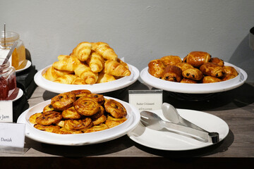 Three types of butter croissants in white plates
