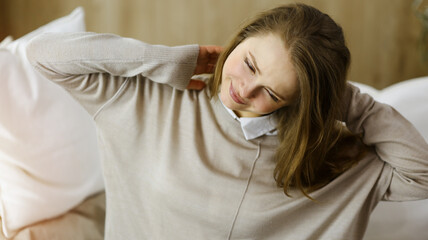 Tired woman massaging rubbing stiff sore neck tensed muscles fatigue from computer work in...