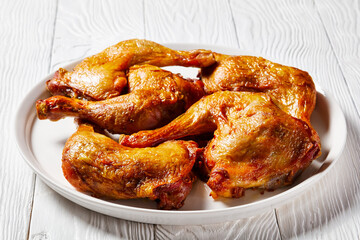 roast chicken legs on a white platter, top view