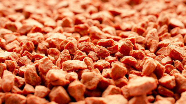 Potassium chloride is a red mineral fertilizer close-up. Red background of fertilizer potassium chloride. Texture of granular potassium chloride is red. Macro.