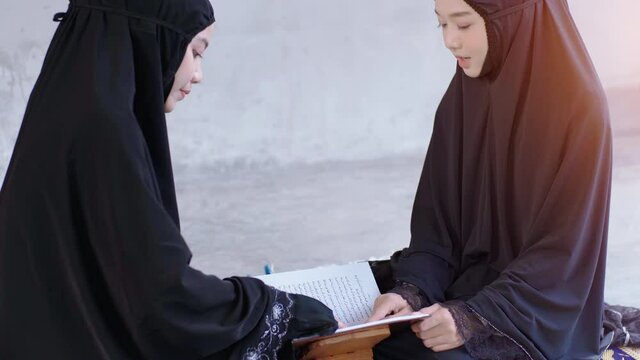 Portrait of an Asian muslim women in a daily prayer at home reciting Surah al-Fatiha passage of the Qur'an in a single act of Sujud called a Sajdah or prostration