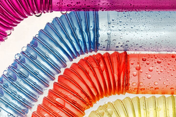 Vier bunte Trinkhalme mit Knick und Wassertropfen