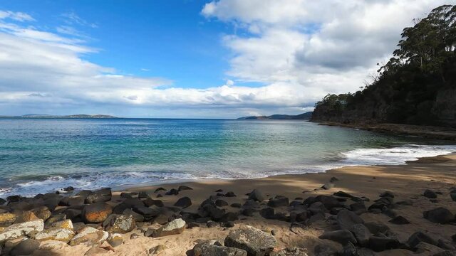 pristine wild landscape at Boronia Beach in Tasmania, Australia with lush vegetation and rocks on the shore
