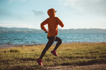 Woman trail runner cross country running in high altitude nature