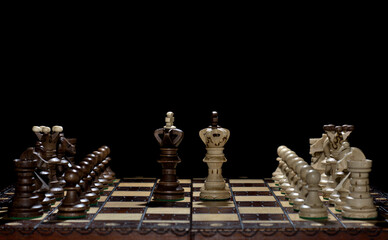 Chess faceoff of both kings on top of a chess board in front of a dark background surrounded by the...