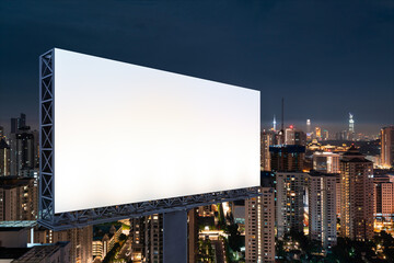 Blank white road billboard with KL cityscape background at night time. Street advertising poster, mock up, 3D rendering. Side view. The concept of marketing communication to promote or sell idea.