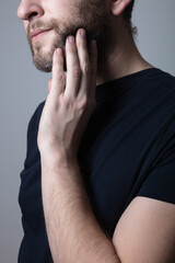 Fototapeta premium a man with a gray beard suffers from itching and rash on his cheeks. Allergic reaction, eczema concept