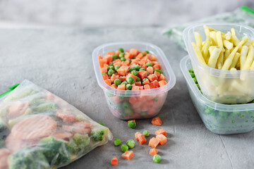 Plastic containers and bags with different frozen vegetables.