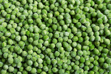Fresh frozen green peas background top view.