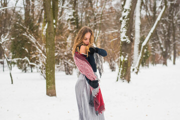 Christmas, New Year, winter holidays concept. Cute teenage girl with curly hair. playing with snow in park.