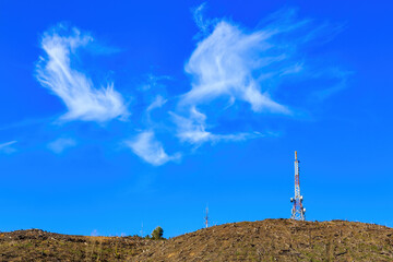 Obraz premium Telecommunications towers on a hilltop, under a blue sky