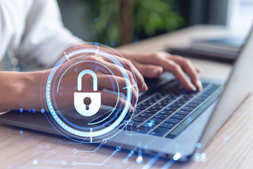 A woman programmer is typing a code on computer to protect a cyber security from hacker attacks and save clients confidential data. Padlock Hologram icons over the typing hands. Formal wear.