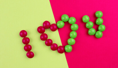 Declaration of love from candies on a pink and green background
