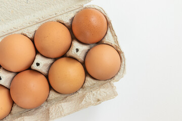 Chicken eggs close-up isolated on white background in cardboard box for transportation.