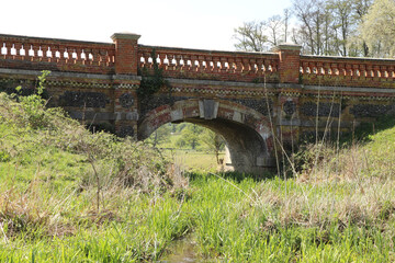 Fototapeta na wymiar Solid brickwork of a bridge across a stream