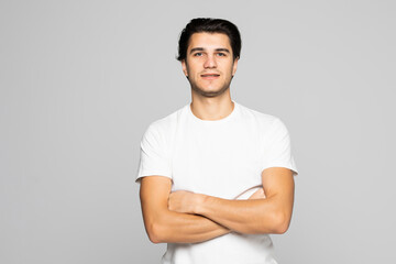 Portrait of a young man with crossed hands isolated on white background