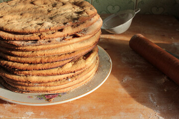 Stack of home-cooked cakes on the kitchen table. Process of cake cooking. Close-up  