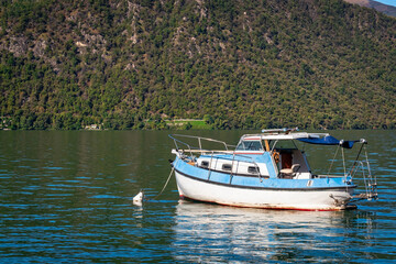 Leisure boat, moored in the Orta Lake (piedmont, Northern Italy) seen from the city of Orta, along the lake shores during early fall season. UNESCO World Heritage Site.