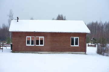 one-story wooden house stands in the snow