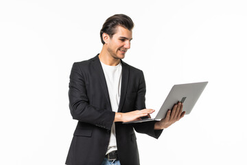 Concentrated on work. Confident young handsome man in shirt and tie working on laptop while standing against white background