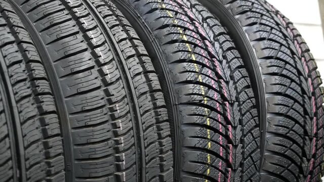 Close-up of new car tires are on the shelf of an auto parts store. Car wheels are sold at a car shop.