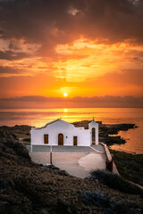 Fototapeta na wymiar Church by the sea with scenic sunrise. an unbelievable atmosphere on Zakyntos on the Greek island. an almost divine light religion and belief. Little white church