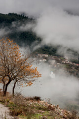 Fototapeta na wymiar View of a mountain village on a cloudy, foggy, winter day (Greece, Agrafa region).