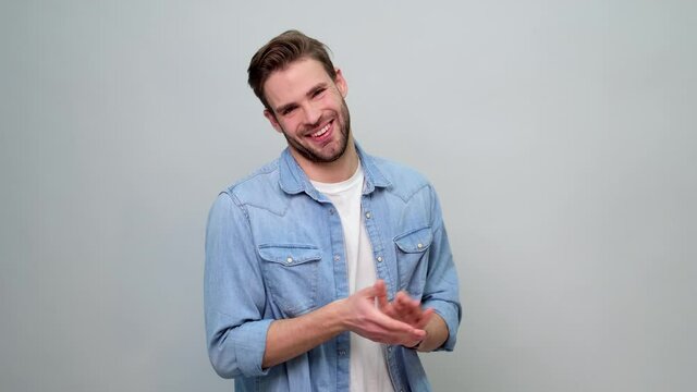 Portrait of Cheerful Young Man Clapping or Applauding over light grey background
