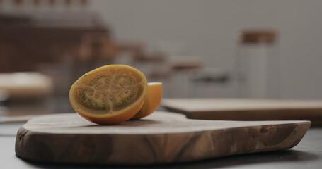 cut in halves lulo fruit on olive wood board with copy space