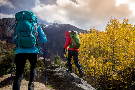 Two backpackers hiking  in high altitude winter mountains