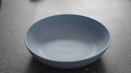 Empty blue ceramic bowl on concrete background