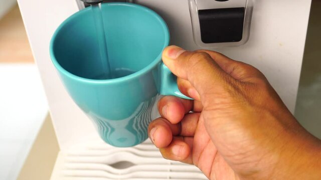 Man getting a cold, refreshing drink from the water dispenser.