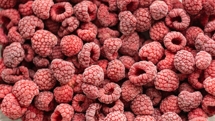 Background of frozen raspberries, healthy food concept, Ripe raspberries with frosty freshness.
