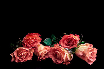 bouquet of red roses on a white vintage table and black background.