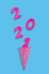 Creative New year concept with ice cream cone and number cake candles. Flat lay design
