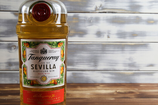 Viersen, Germany - May 9. 2020: Close up of isolated  Tanqueray sevilla gin bottle with timber planks wood background (focus on upper part of bottle)