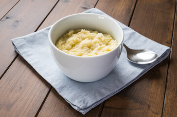 Millet porridge in the bowl on the wooden background