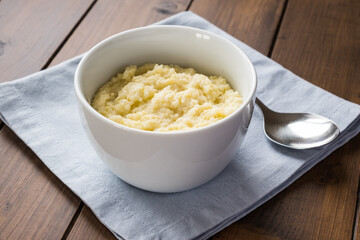 Millet porridge in the bowl on the wooden background, close up
