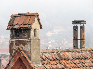 Old medieval house with red brick roof tiles and a chimney in Sighisoara, Romania.